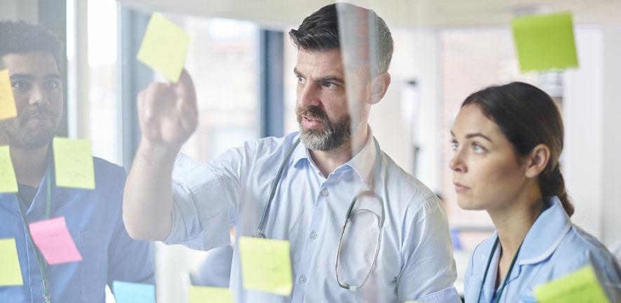 Medical team in a training workshop looking at notes on a wall