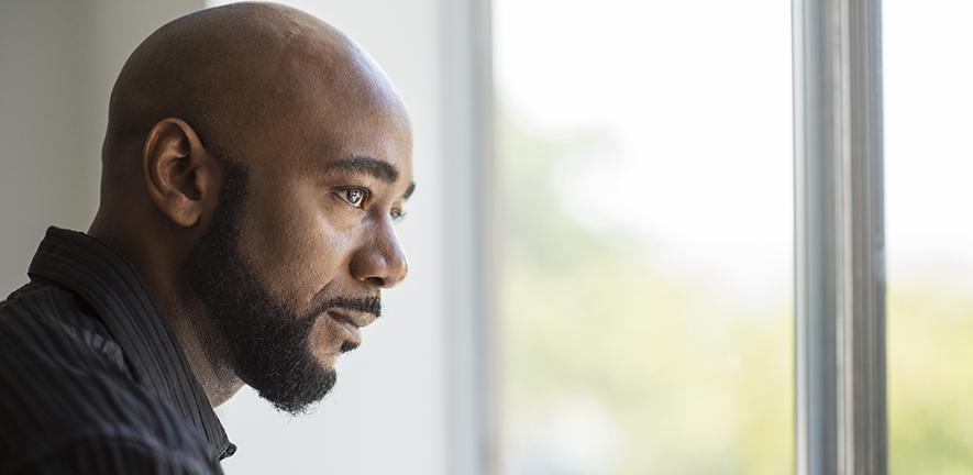 Black man looking out window