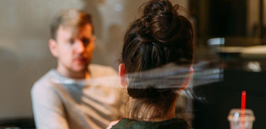 Two people speaking, sat at a table