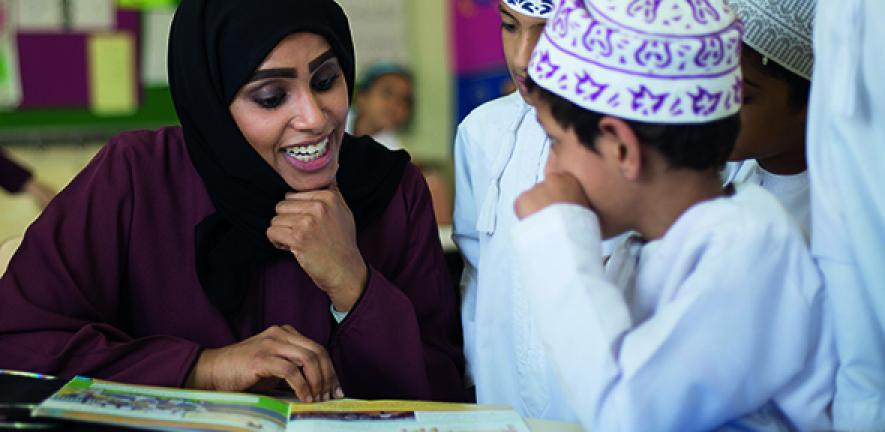 School pupils in Oman reading with their teacher. Image: Cambridge Partnership for Education