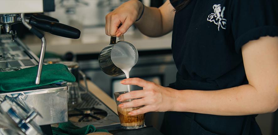 A barista making a coffee