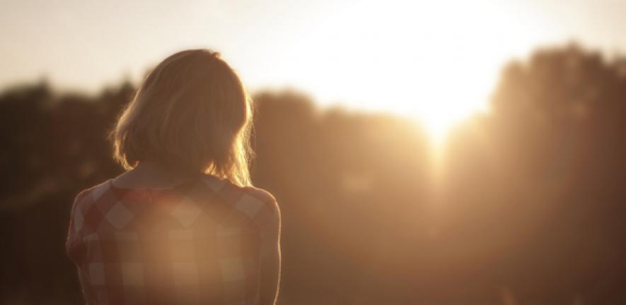 Woman contemplates sunrise