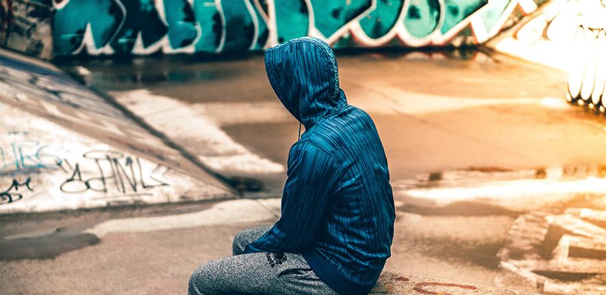 Teenager sitting near graffiti