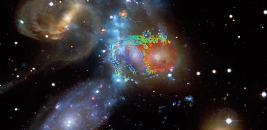 Blue, green and red colours, according to velocities derived from the WEAVE spectra, are overlaid on a composite image of Stephan’s Quintet, which features galaxy star light (CFH telescope), and X-ray emission of hot gas (blue vertical band, Chandra X-ray observatory). 