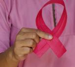 Woman holds pink breast cancer awareness ribbon. 