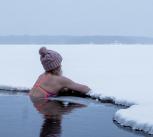 Woman in cold water resting on the ice