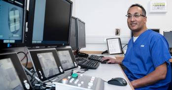 Dr Raj Jena in front of a computer