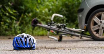 Cycling helmet lying on the floor by a crashed bicycle