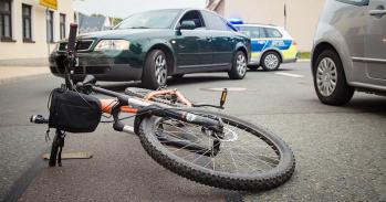 Bicycle lying in the road in front of a car