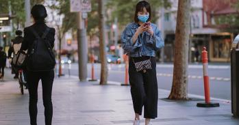 Woman in face mask walking down the street during a coronavirus lockdown
