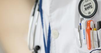 Doctor's white coat with stethoscope and pens