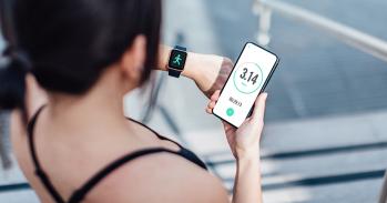 Woman checking her smart watch and mobile phone after run