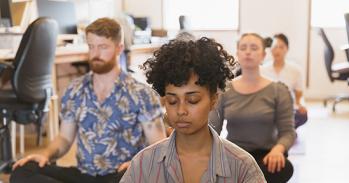 Serene creative business people meditating in office