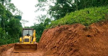 Digger making tracks in forest