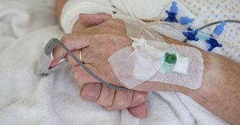 Hands of senior man with cannulae and band-aid being in intensive care