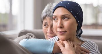 An Asian woman in her 60s embraces her mid-30s daughter who is battling cancer - stock photo