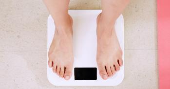 Person standing on white digital bathroom scale