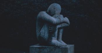 Statue of a figure hugging its knees