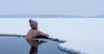 Woman in cold water resting on the ice