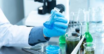 Person in laboratory holding a flask