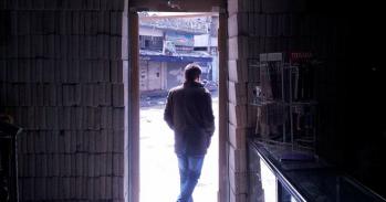 Man framed in pharmacy entrance, in Syria