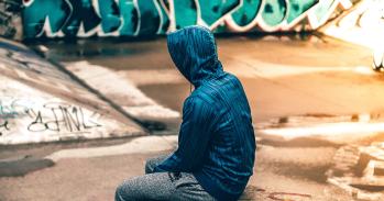 Teenager sitting near graffiti