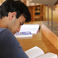 Student at a desk reading a book