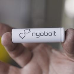 A hand holding a Nyobolt battery