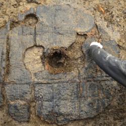 Excavation of Bronze Age Wheel at Must Farm one metre in diameter, with hub clearly visible. 