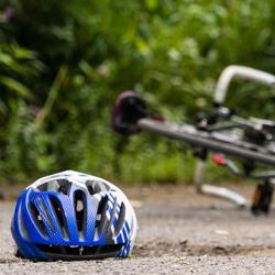 Cycling helmet lying on the floor by a crashed bicycle