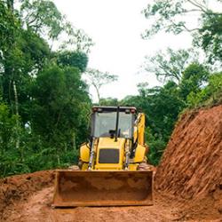 Digger making tracks in forest
