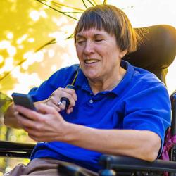 Woman with multiple sclerosis in a wheelchair using her phone