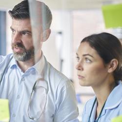 Medical team in a training workshop looking at notes on a wall