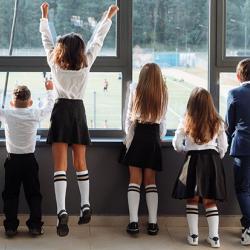 School children watching a sports game from indoors