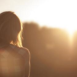 Woman contemplates sunrise